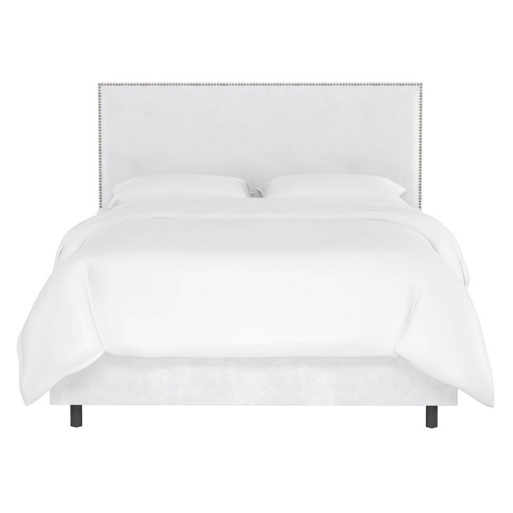 a bed with white linens and pillows on top of it, in front of a white background