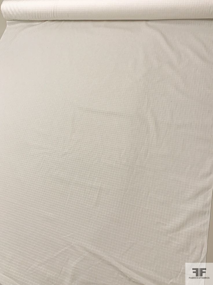 a white sheet that is laying on top of a bed