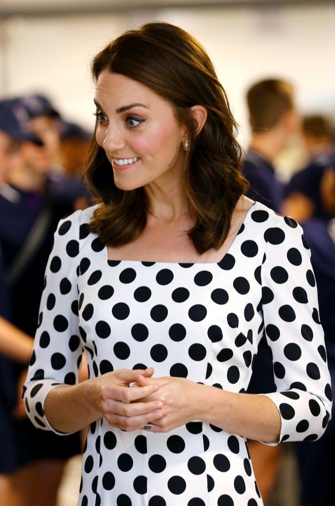 the young woman is wearing a polka dot dress and holding her hands in her pockets