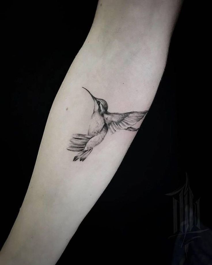 a small hummingbird tattoo on the arm