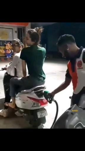 two people are sitting on a motorcycle and one person is holding the handlebars