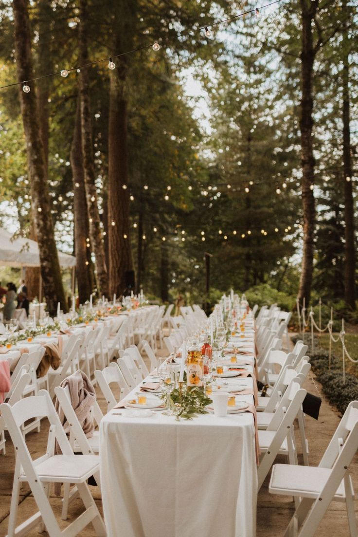 tables set up for an outdoor wedding reception in the woods