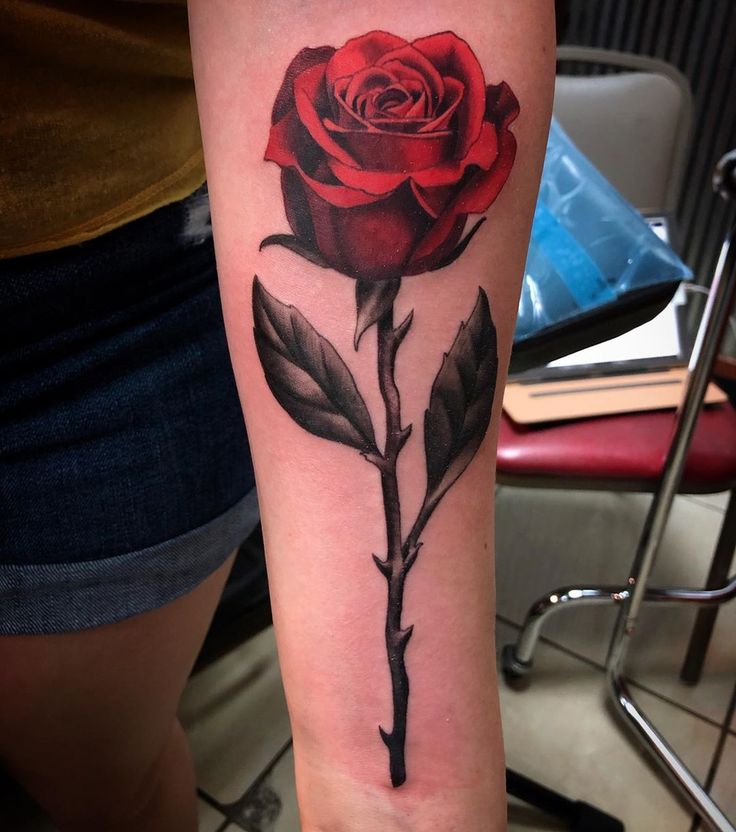 a red rose tattoo on the arm