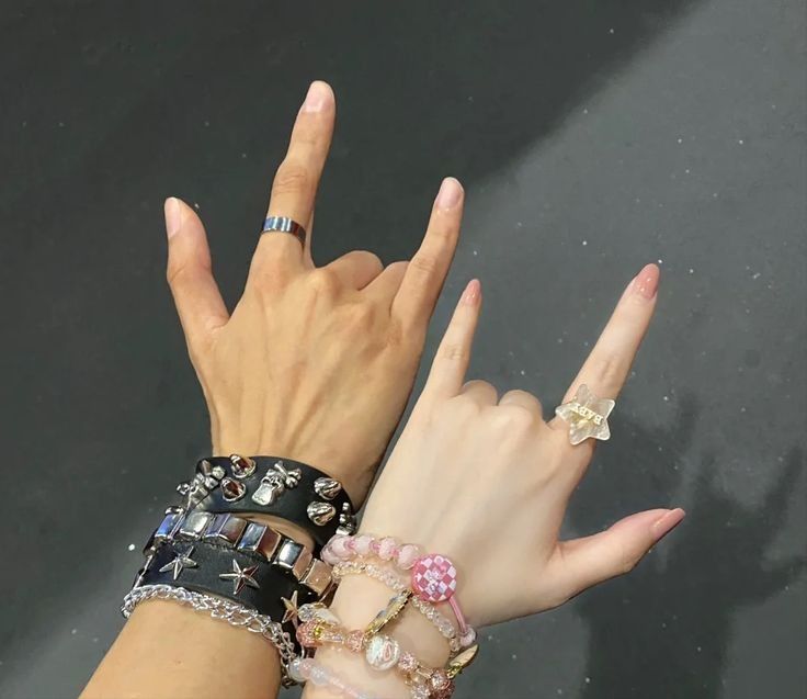 two women's hands with rings on their fingers and one holding her hand up