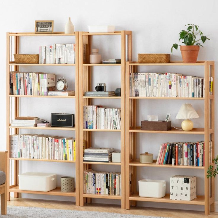 a living room filled with lots of books on top of wooden shelves next to a chair