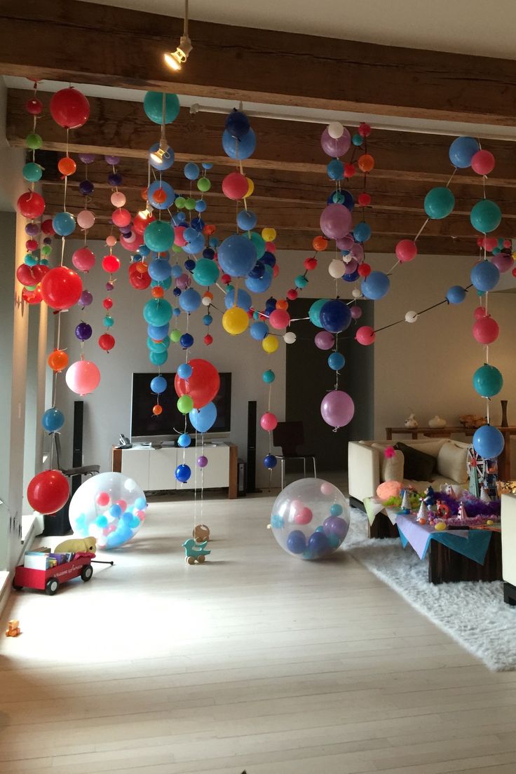 a room filled with lots of balloons floating from the ceiling