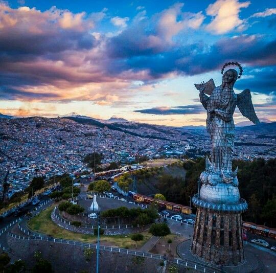 an aerial view of a city with a statue in the foreground