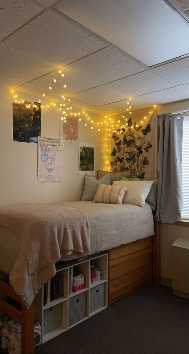 a room with a bed, bookshelf and lights on the wall above it