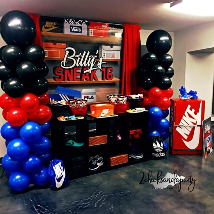 some balloons are hanging from the ceiling in front of a wall with nikes on it