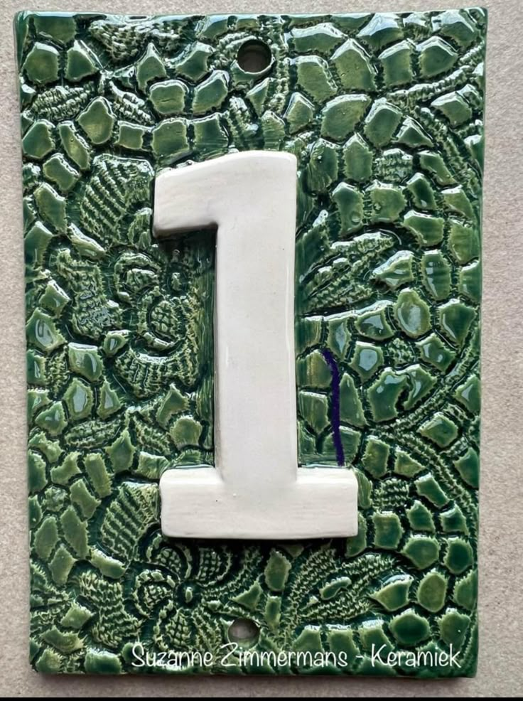 a green and white tile with the number one on it