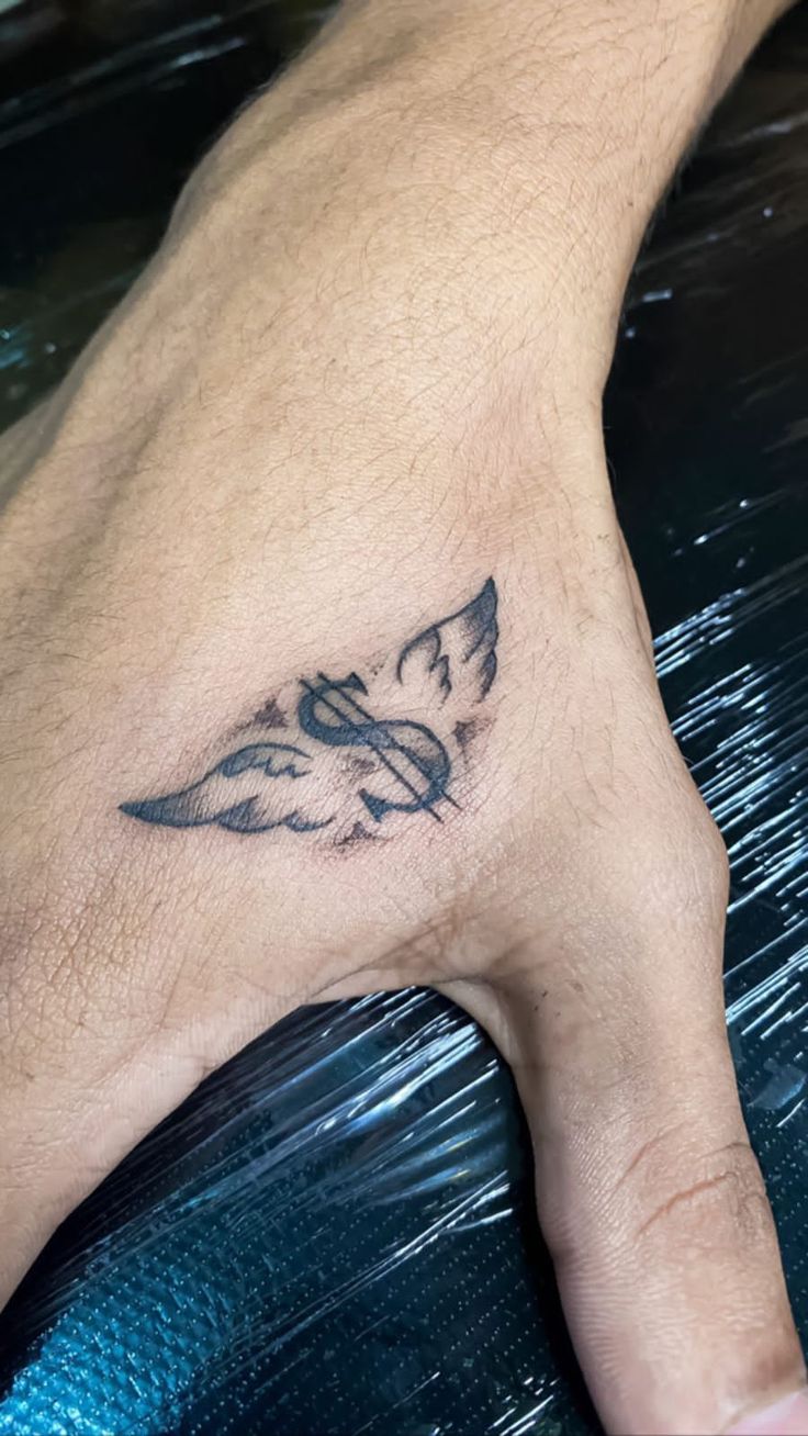 a man's foot with a bird tattoo on the top of his left foot