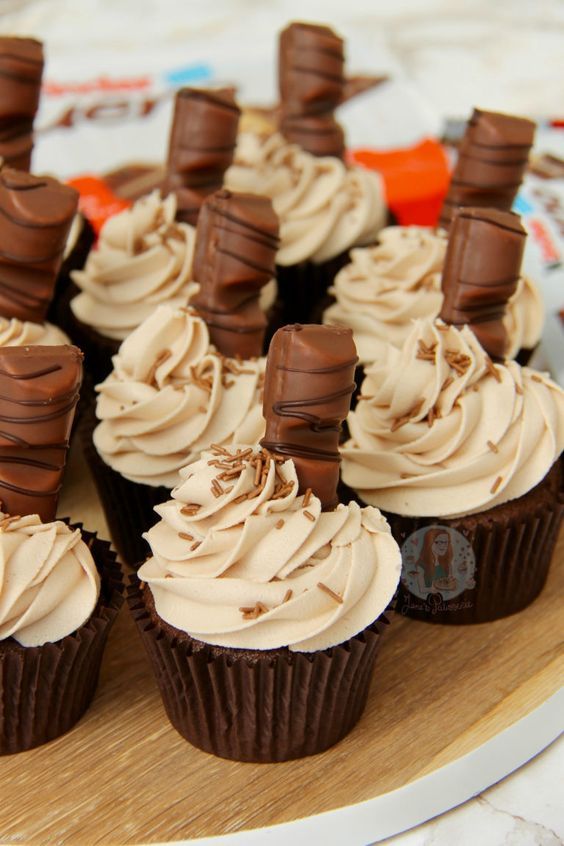 chocolate cupcakes with white frosting on a wooden platter