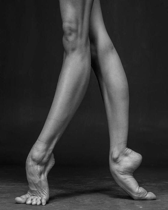 black and white photograph of a ballerina's legs with their feet in the air