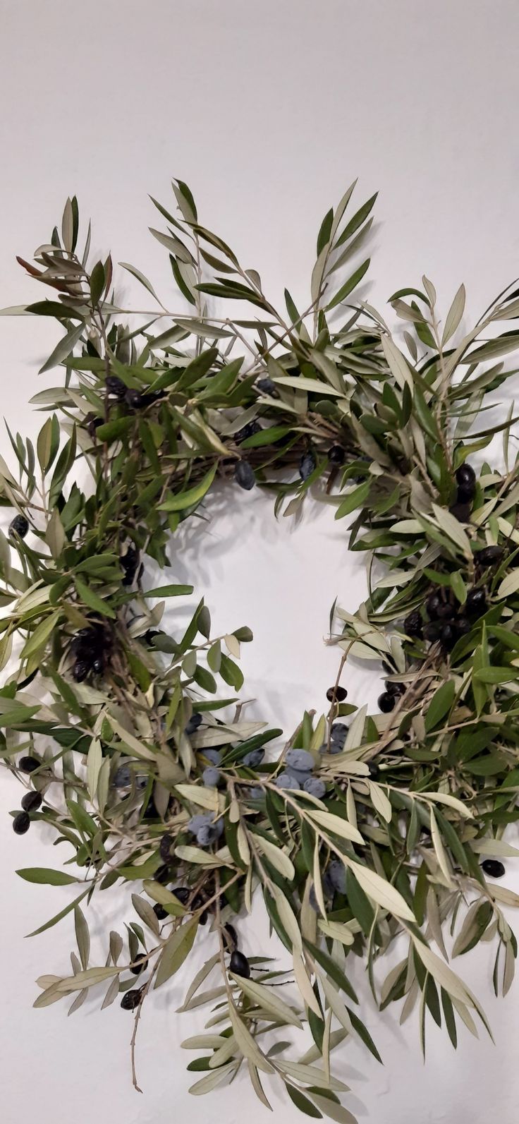 an olive wreath with black berries and green leaves