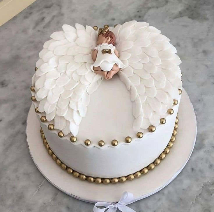 a white cake decorated with an angel on top