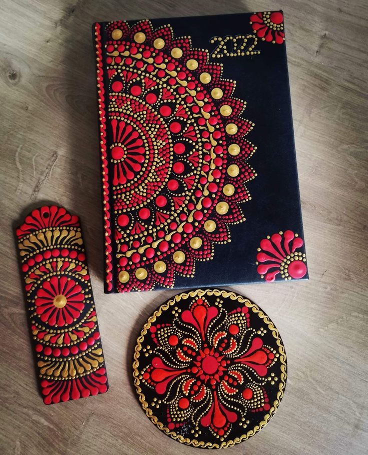 a red and black table cloth next to a small round object on top of a wooden floor