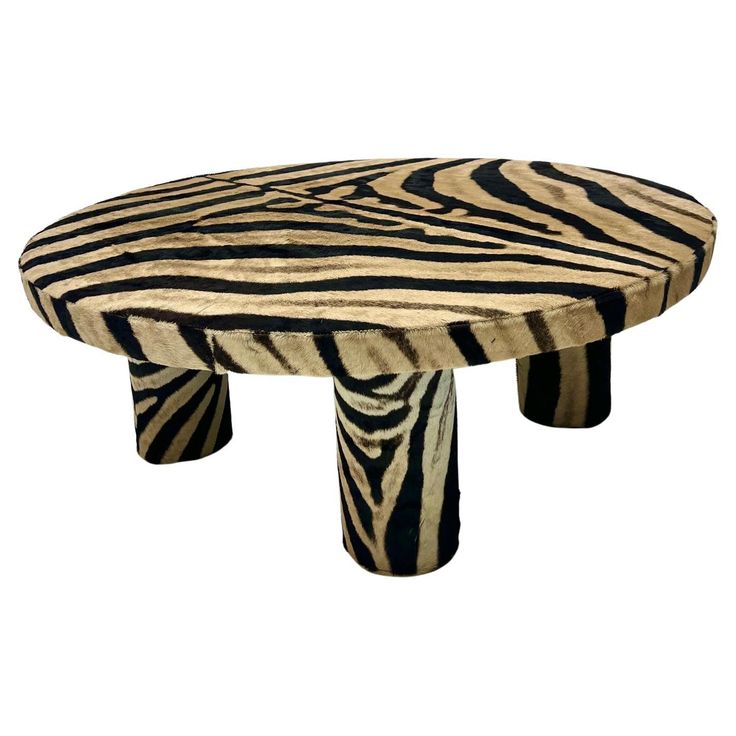 a zebra print table with two legs and one foot on it's end, in the shape of a stool