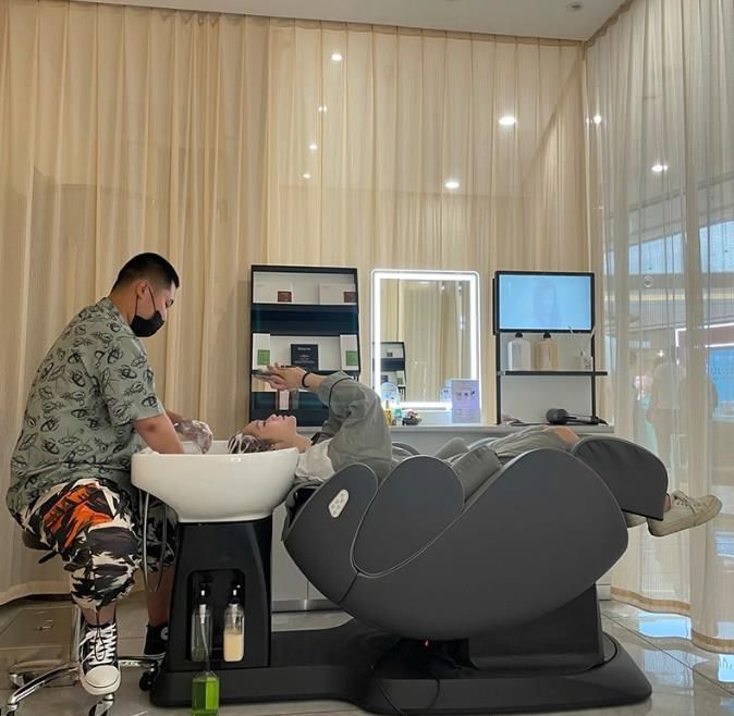 a man sitting in a bathtub next to a sink