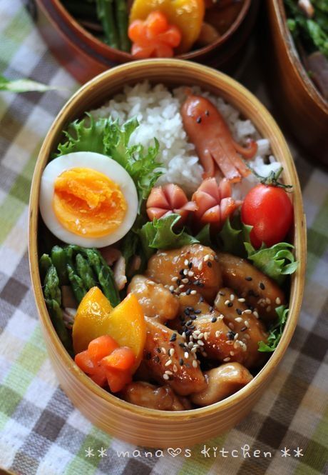 a wooden bowl filled with rice, meat and veggies on top of a table