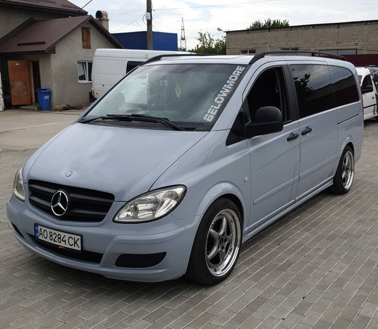 a grey van parked on top of a brick road