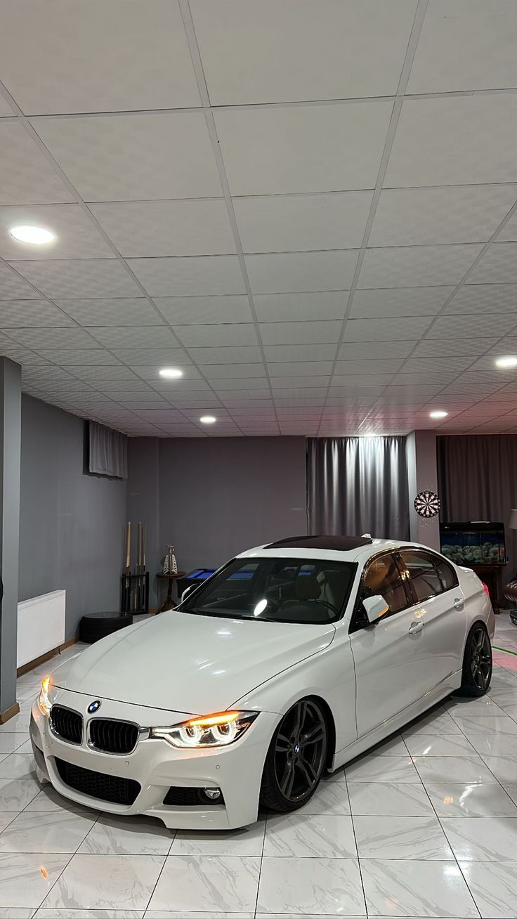 a white car is parked in a showroom