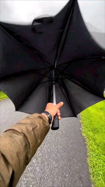 a person is holding an umbrella over their head while walking down a path in the grass