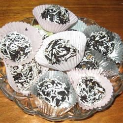 there are many cupcakes in the glass plate on the table with white frosting