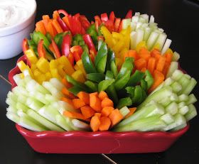 a red bowl filled with cut up vegetables on top of a black table next to a white bowl