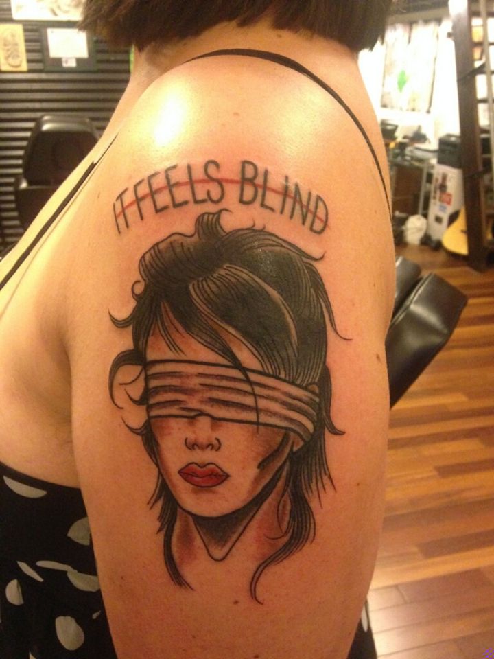 a woman with a blindfold on her head has a tattoo that reads, feels blind