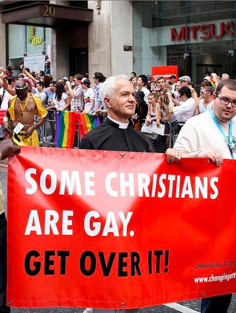 two men holding a sign that says some christians are gay, get over it