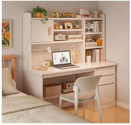 a white desk with a laptop on top of it next to a bed and bookshelf