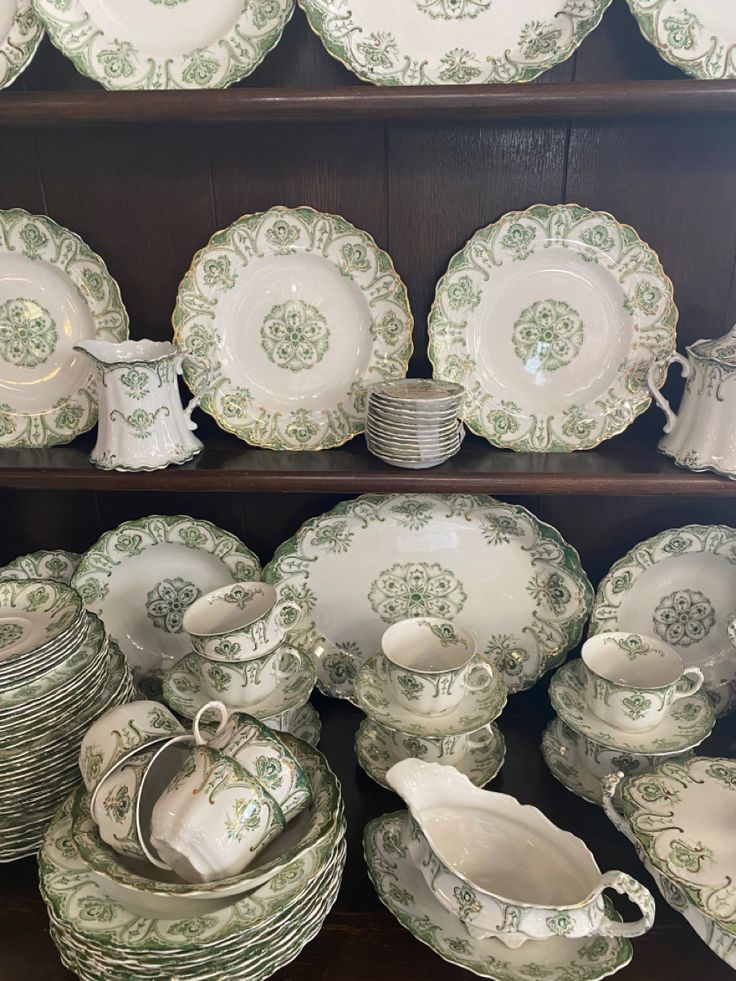 an assortment of green and white china on display