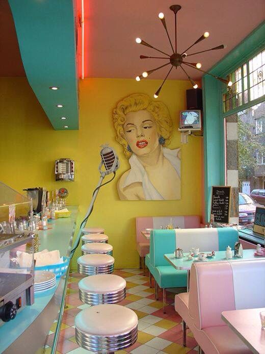 the interior of a restaurant with brightly colored booths and tables in front of a painting on the wall