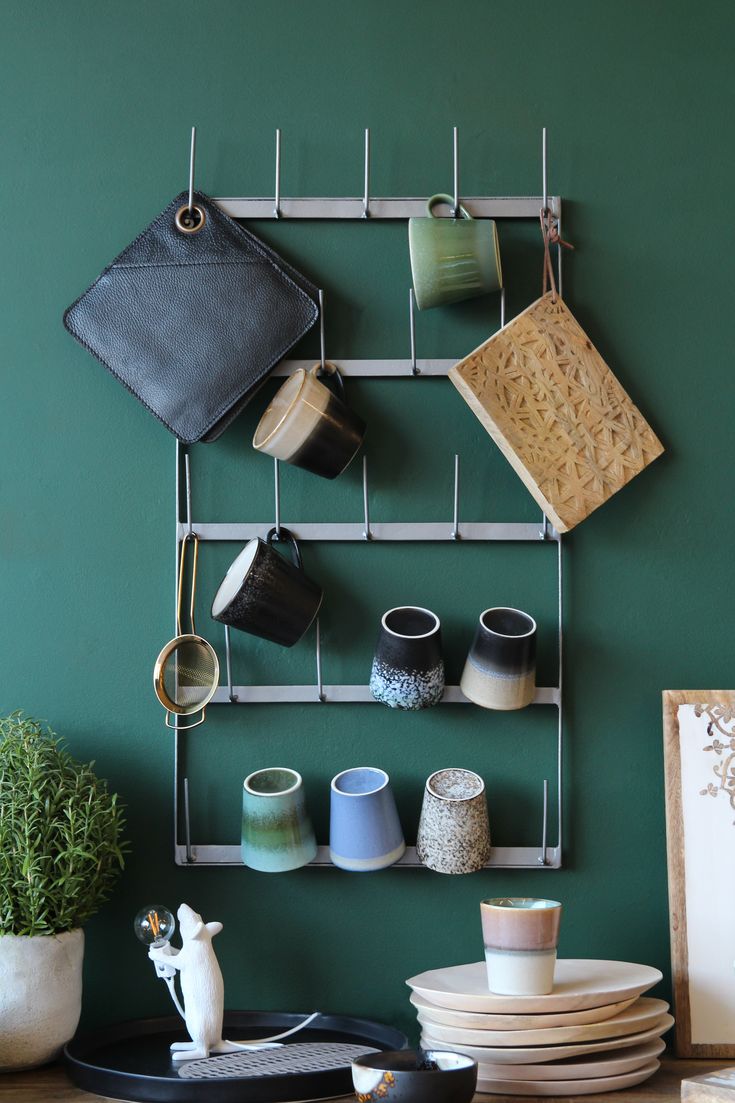 a rack with cups and plates on it in front of a wall mounted pot holder