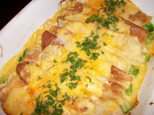 a cheesy casserole in a white dish with parsley on top