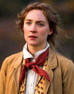 a woman wearing a brown jacket and red bow tie