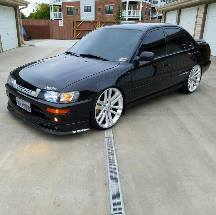 a black car parked in front of two garages