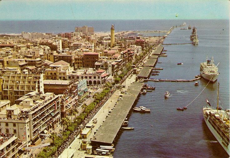 an aerial view of a city with ships in the water and buildings on both sides