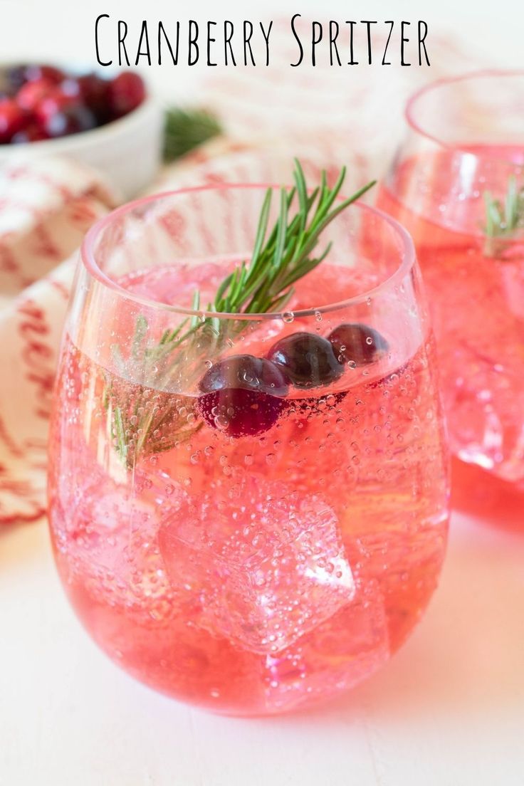 two glasses filled with cranberry spritzer and garnished with rosemary