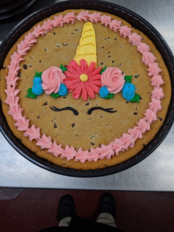 there is a cake decorated with flowers and a unicorn horn on the top of it