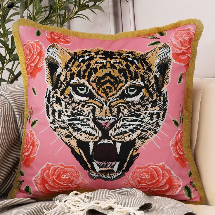 a pink pillow with an image of a tiger's face and roses on it