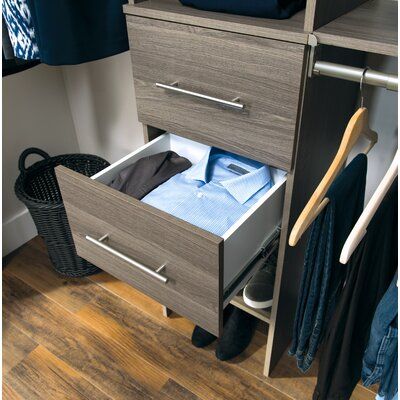 an open drawer in a closet with clothes