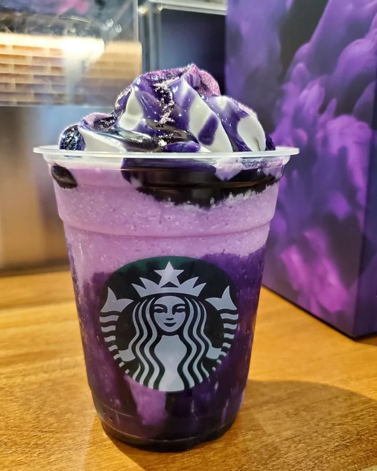 a purple and white drink sitting on top of a wooden table