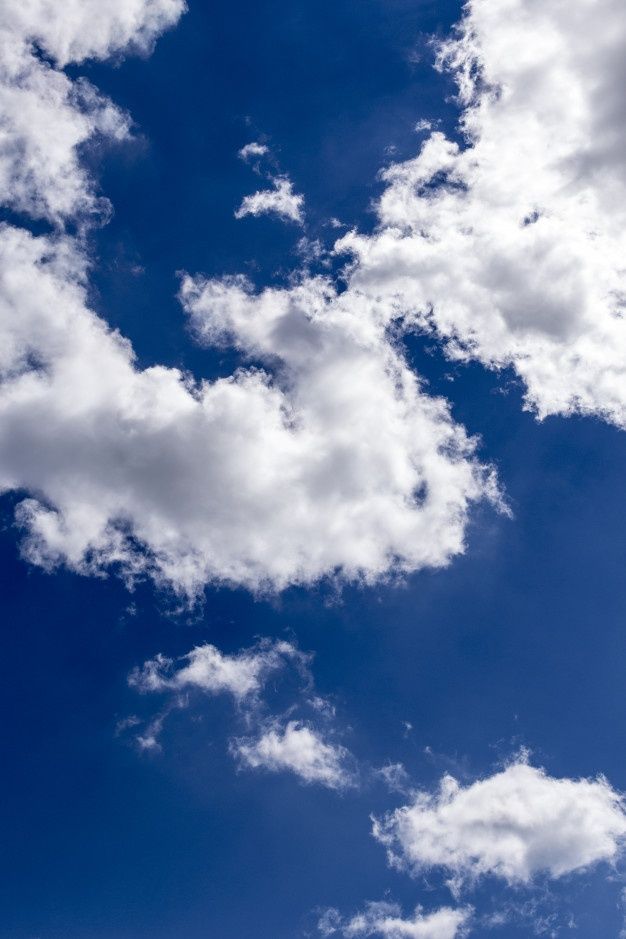 the airplane is flying high in the blue sky with white clouds above it and below