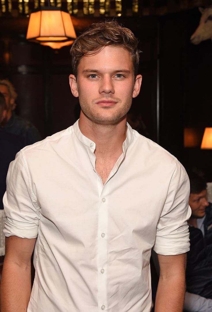 a man standing in front of a table wearing a white shirt