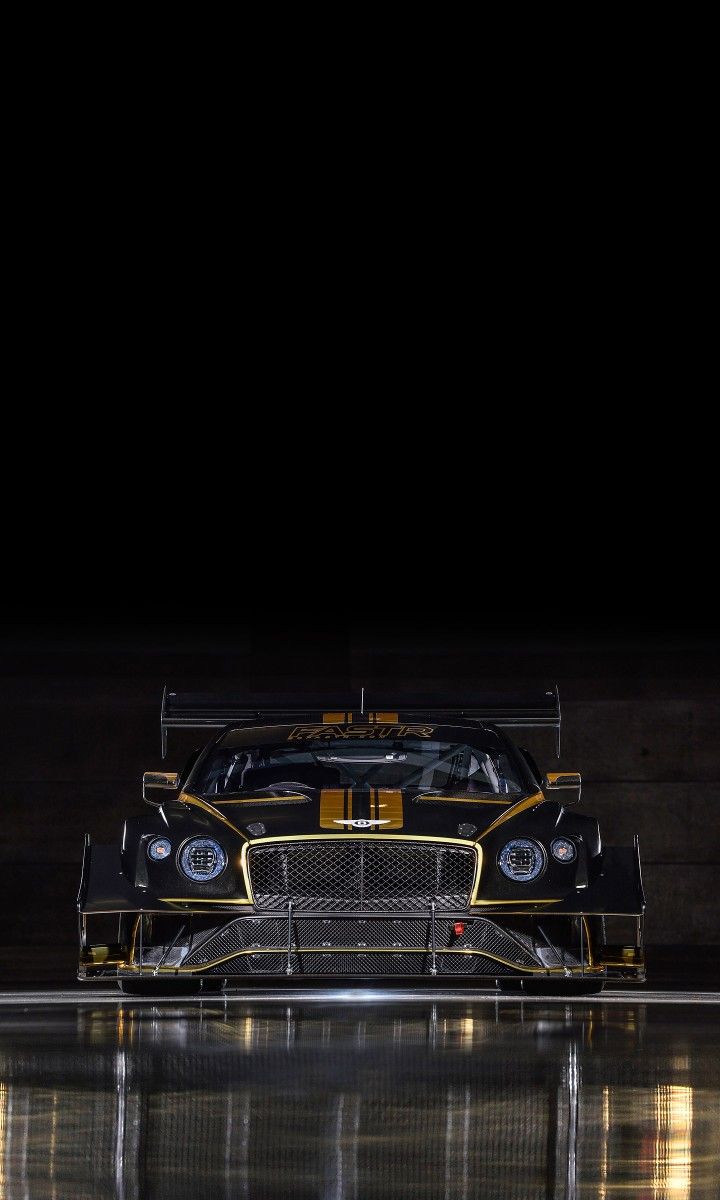 a black and yellow race car parked in the dark