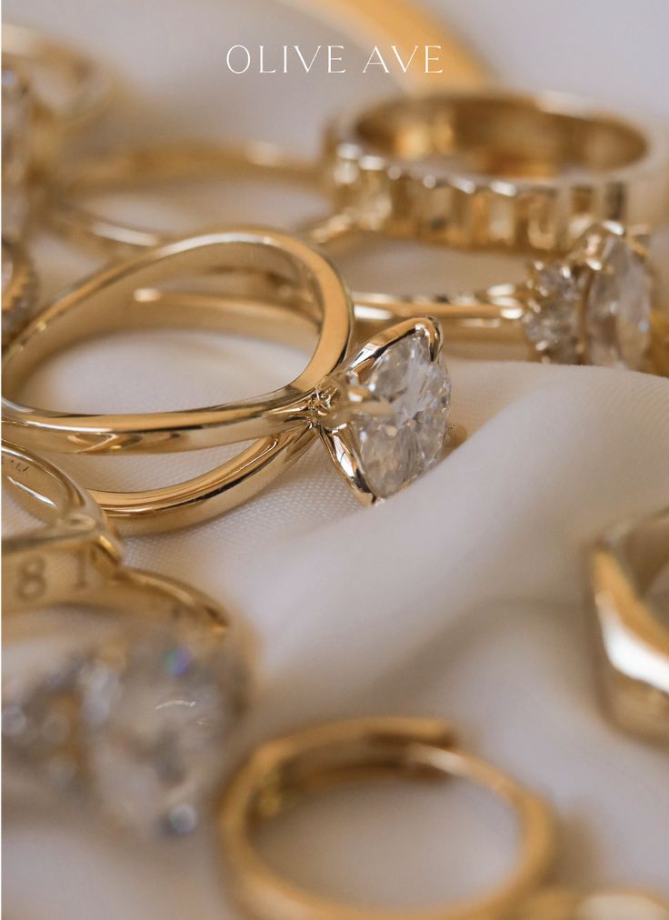 several different types of wedding rings on a white cloth