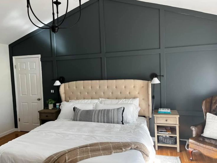 a bedroom with black walls and white bedding