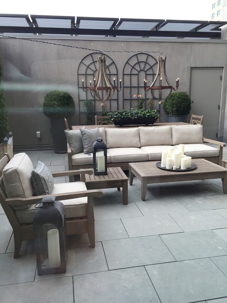 an outdoor living area with couches, tables and candles