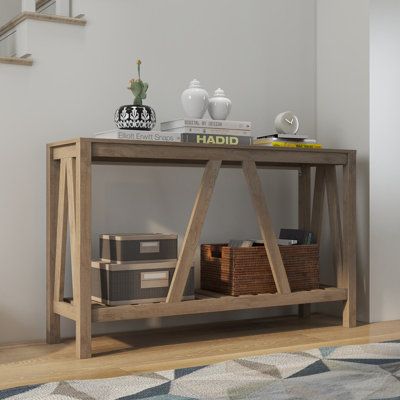 a wooden table sitting on top of a hard wood floor next to a stair case